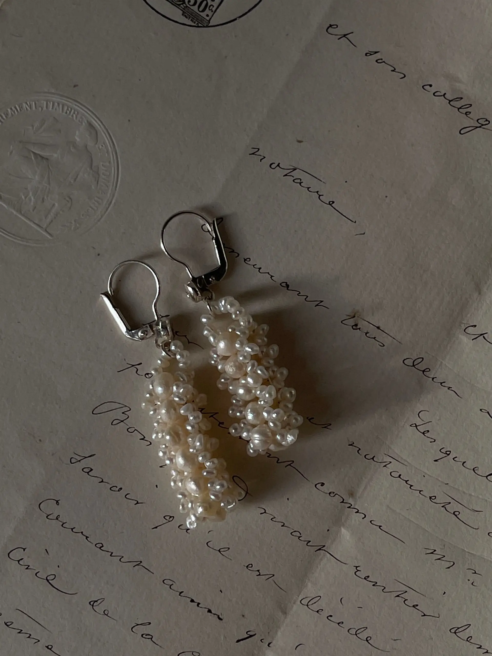 Pearl earrings on a vintage letter